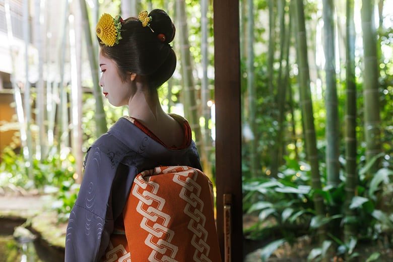 Elegant tea setting with maiko performance atmosphere beside a bamboo garden