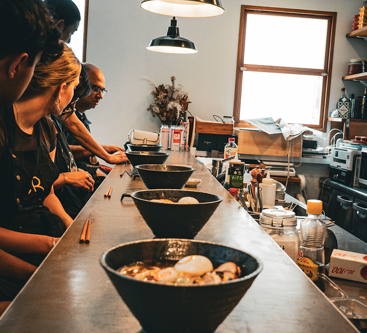 Bowls of ramen lined up along a small-group cooking counter in Meguro, Tokyo